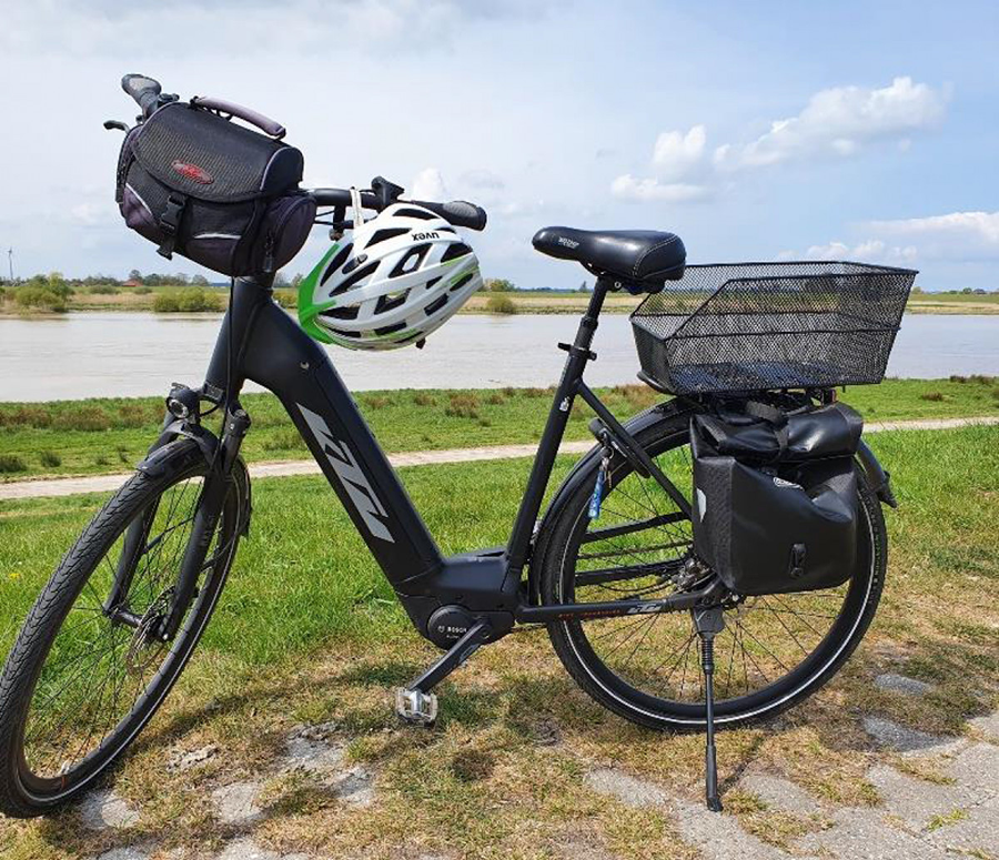 An einem E-Fahrrad hängt ein Fahrradhelm.